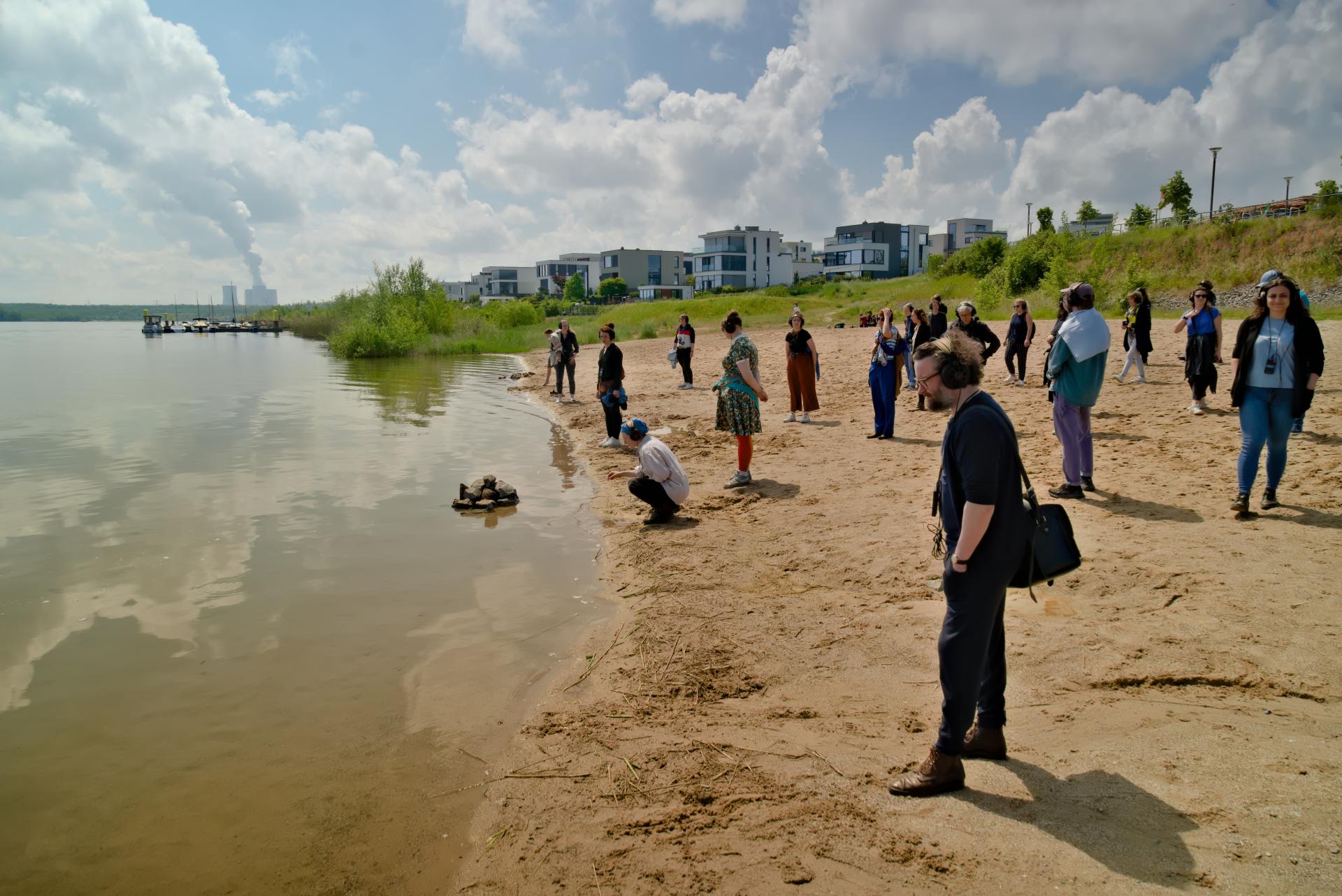 Group of people with audio guides standing on the shore of Lake Zwenkau