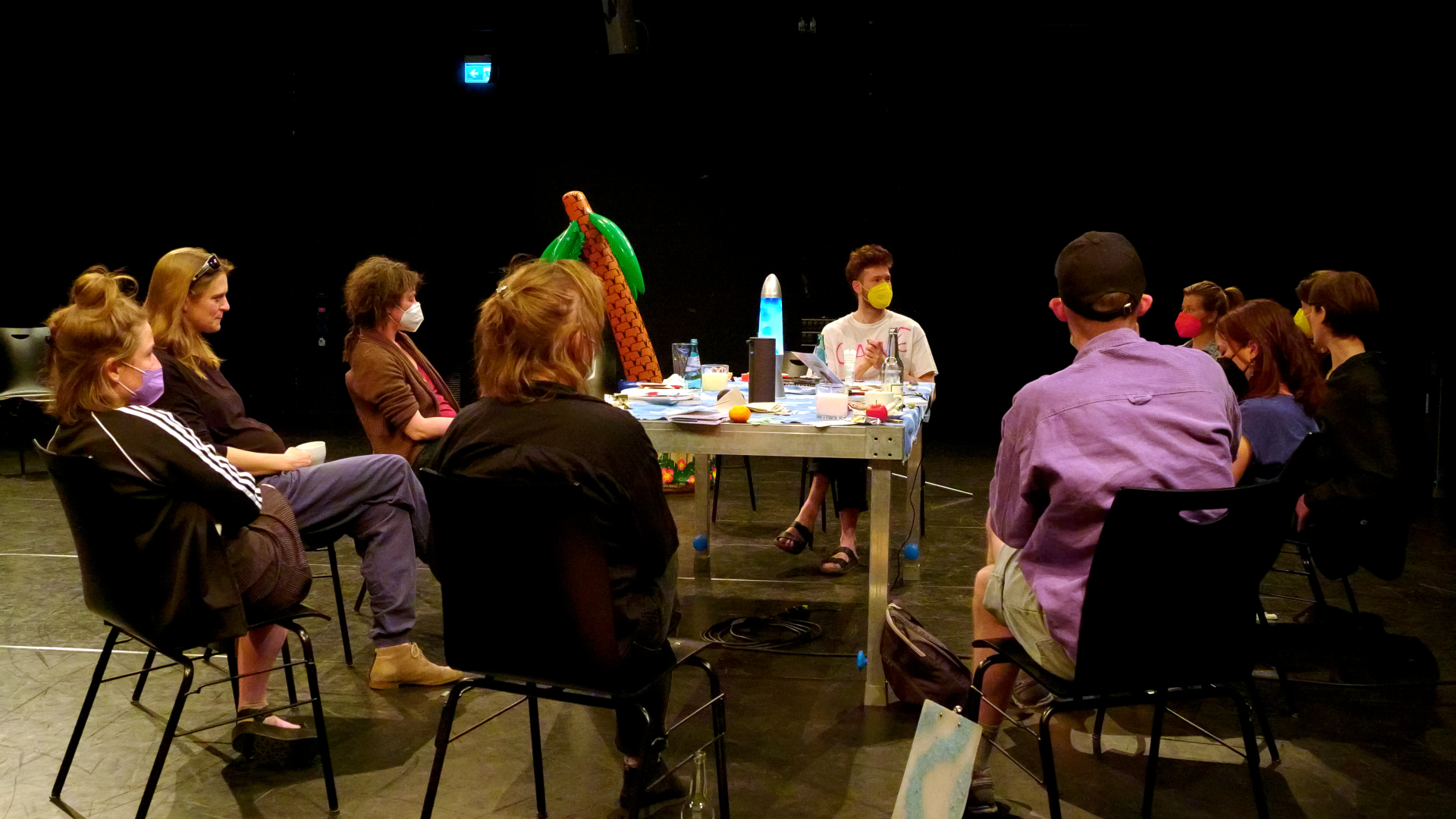 Eine Gruppe von Menschen mit FFP2-Masken, an einem Tisch sitzend