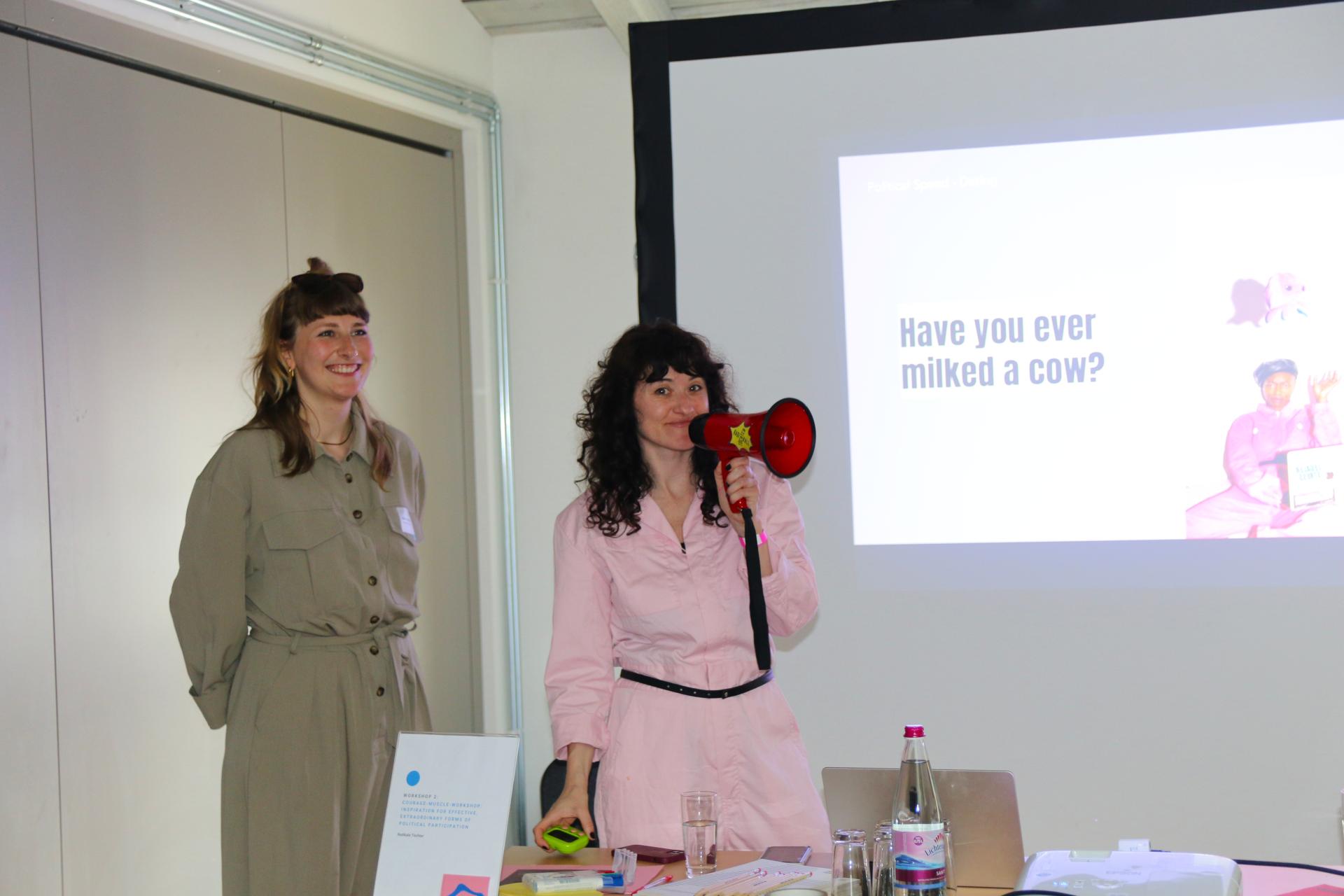 Luise Gabel and Nele-Marie Wolfram from the Radikale Toechter lead through the courage-muscle workshop with a megaphone