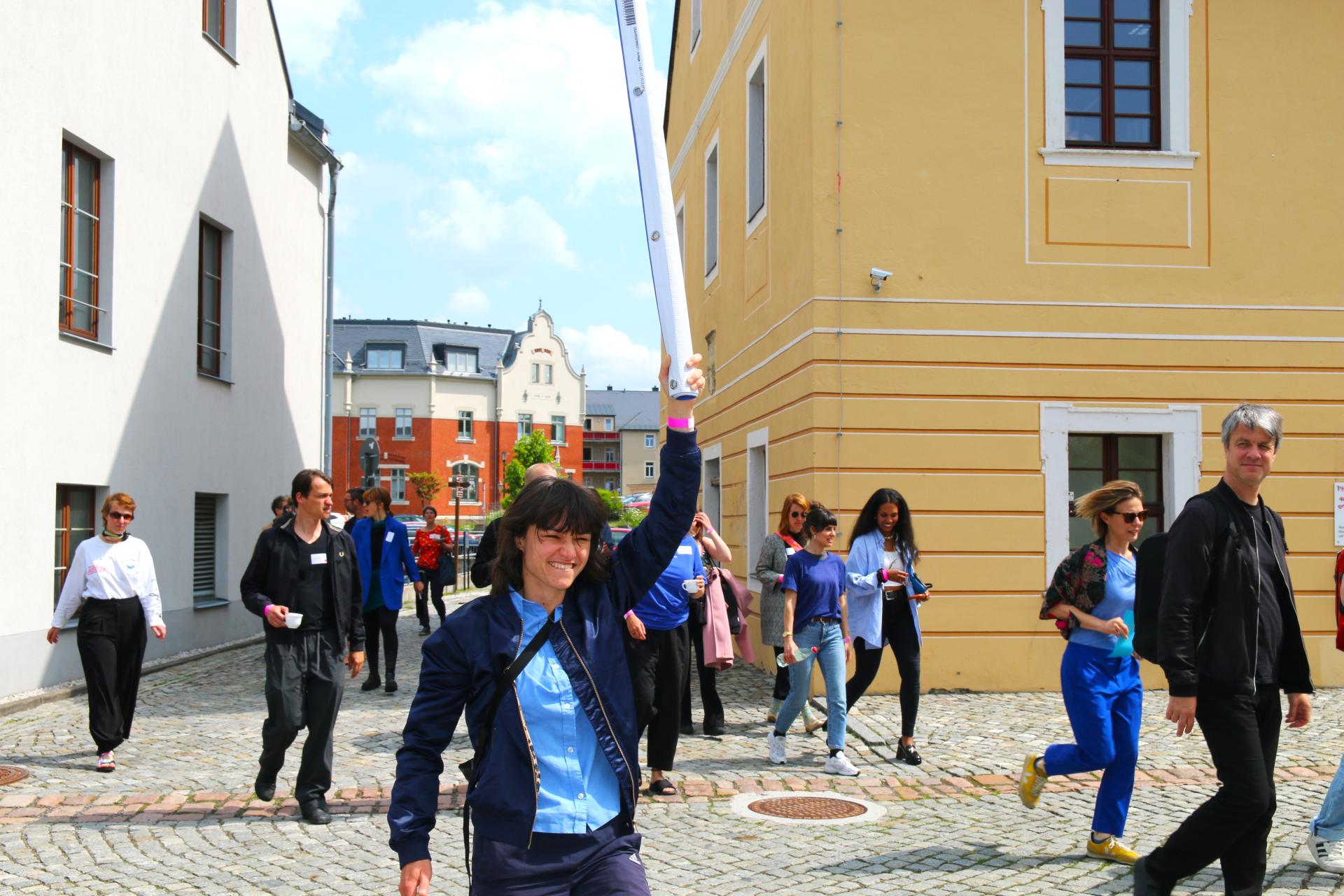 Group of conference participants on the move, led by the “Meckerchor”