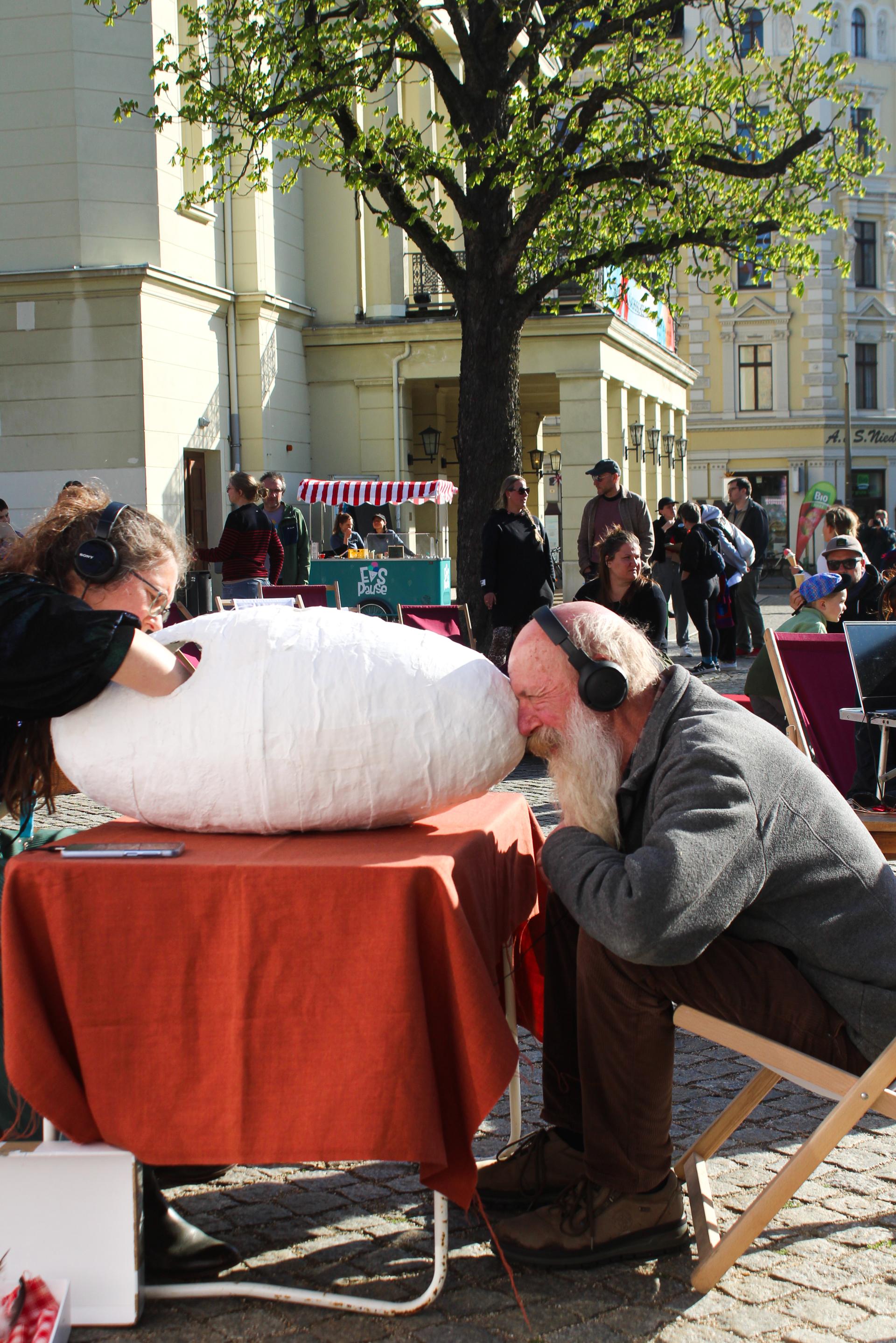 A spectator with a long beard, looking into a peep-box