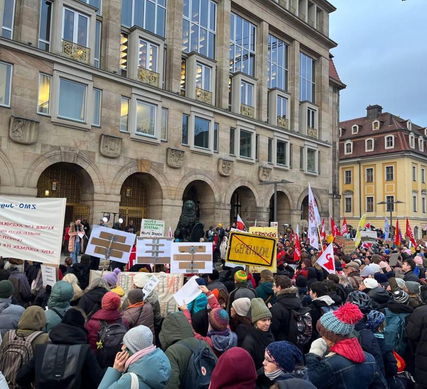 Menschenmenge einer Demonstration in Dresden mit Pappschildern